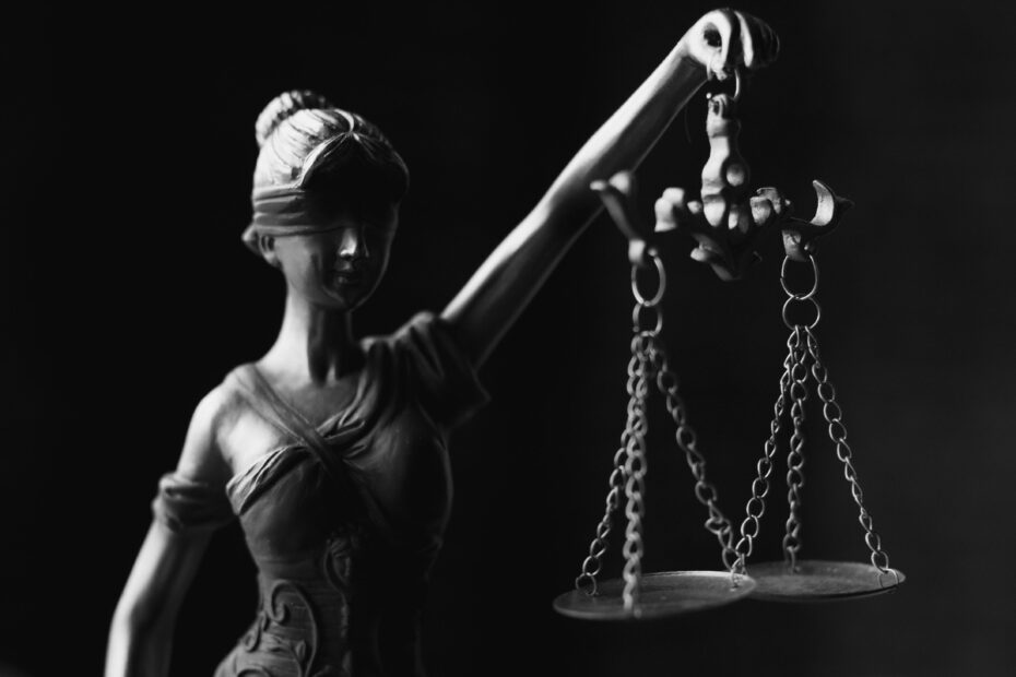 Black and white picture of Lady Justice blindfolded holding a set of scales